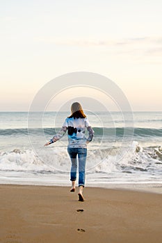 Woman runs into the sea. Storm, sunset