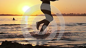 Woman Runs on Shallow Water at Golden Sunset along the Beach. Slow Motion 240fps