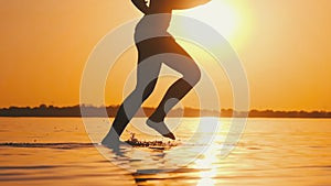 Woman Runs on Shallow Water at Golden Sunset along the Beach. Slow Motion 240fps