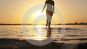 Woman Runs into Shallow Water at Golden Sunset on the Beach. Slow Motion 240 fps