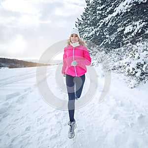 A woman runs in the snow in the winter mountains. Sports, fitness - inspiration and motivation. Woman jogging outdoors.