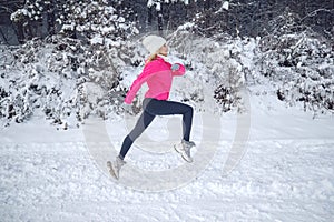 A woman runs in the snow in the winter mountains. Sports, fitness - inspiration and motivation. Woman jogging outdoors.