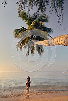 Woman runs to the ocean on the tropical beach
