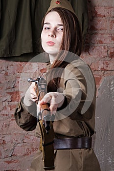 Woman in Russian military uniform shoots a rifle. Female soldier during the second world war.