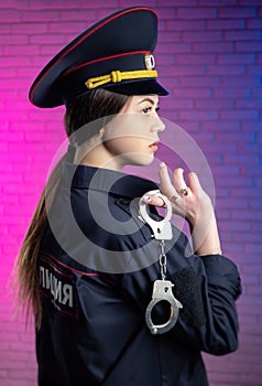 a woman in a Russian police uniform with handcuffs English translation Police
