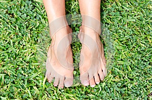 woman's bare feet on green grass