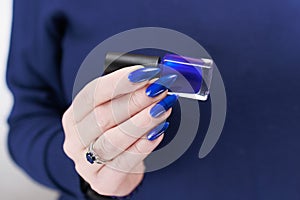 Woman's beautiful hand with long nails and blue manicure