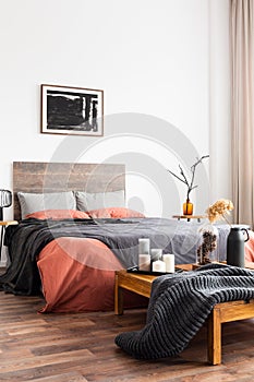 Woman`s bedroom with natural decorations, woolen blanket and coral bedclothes photo