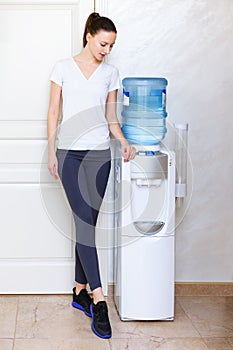 Woman, 20s, caucasian, standing at water cooler wearing sportwear photo
