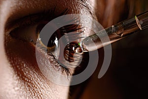 Woman`s eye and eyedropper photo