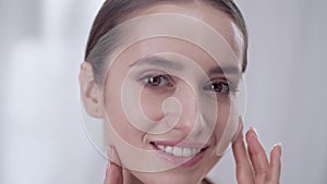 Woman`s Face Care. Smiling Female Touching Skin On Face