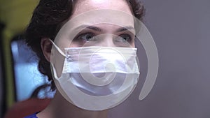 Woman`s face in respiratory mask look at somethig.
