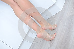 Woman`s feet on the floor