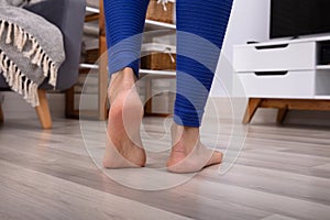 Woman`s Feet Walking On Hardwood Floor