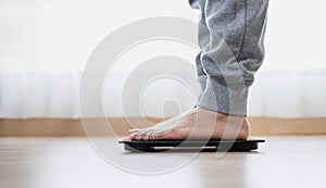 Woman`s feet weighing on scales. weight loss, self care and body Concept