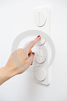 Woman's finger on light switch