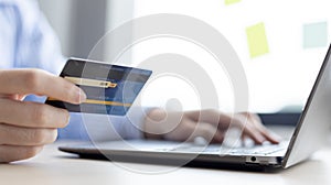 Woman`s finger presses a keyboard and holds a credit card to register for payment or online transactions