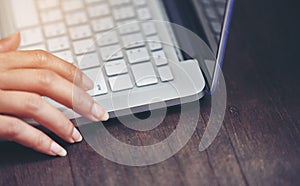 A woman finger is pressing the enter key on her keyboard.