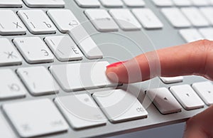 Woman's finger pressing keyboard button