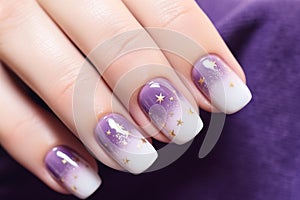 Woman\'s fingernails with purple and white colored nail polish design with golden stars