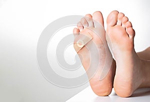 Woman`s foot with glued medical plaster for plantar wart. Treatment of calluses and warts on the feet. Copy space for text