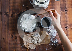 A woman`s hand adding flour to make sourdough. Bakery concept