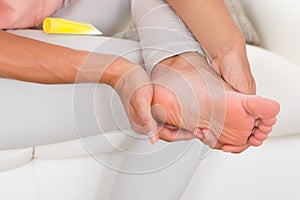 Woman`s Hand Applying Cream On Foot