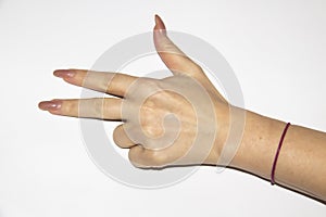 Woman`s hand with bent two fingers and a red thread on the wrist. Female hand have a long nails and show three fingers