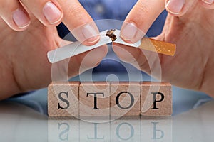 Woman Breaking Cigarette Over Stop Wooden Blocks