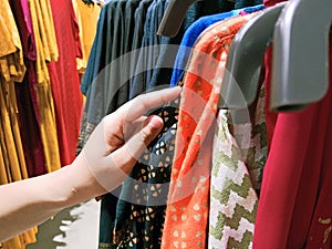 Woman`s hand choosing her outer garments