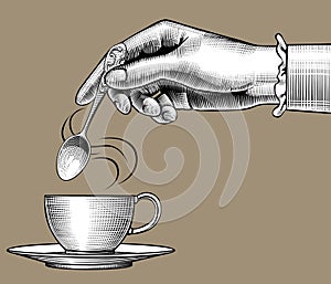 Woman`s hand with a coffee cup and spoon photo