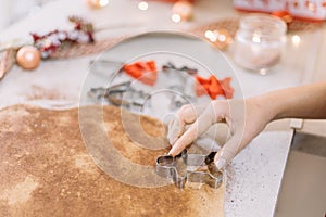 Woman`s hand cutting a rollout cookie dough