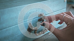 A woman's hand with decorated nails opening the lock of a box