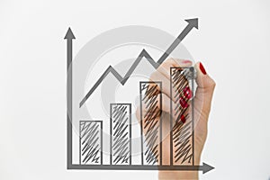 Woman`s hand drawing a graph. Growth and business concept