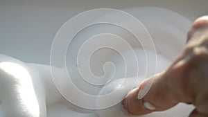Woman`s hand draws circles on the foam
