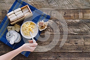 A woman`s hand eating guava sandwiches on a dark wooden background. Concept of Latin food. Copy space. Top view