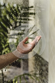 Woman's hand feeling the water. Detail of a woman's hand in the outside tropical shower