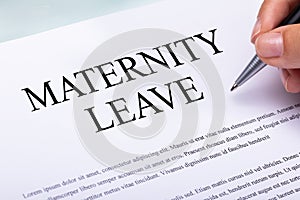 Woman`s Hand Filling Maternity Leave Form Over Desk