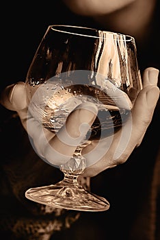 Woman`s hand with glass of alcohol drink