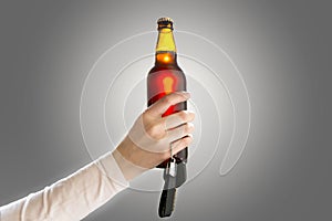 Woman`s hand holding bottle of beer and car keys. Do not drink a