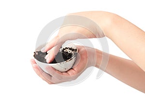 Woman& x27;s hand holding bowl of coffee grounds for skin scrub, heal