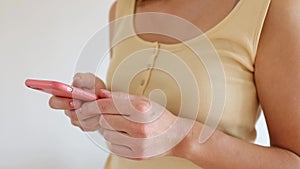 Woman's hand holding cellphone in hands, enjoying web surfing useful information. checking email, reading media news