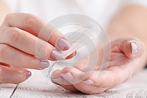 Woman`s hand holding clean cotton tampon close-up. Young woman p