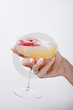 woman's hand holding daiquiri cocktail with strawberry