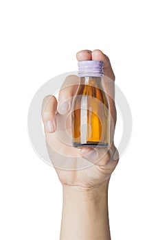 Woman`s hand holding empty small brown medicine bottle liquids transparent on white background.