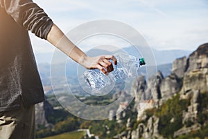 Woman`s hand holding empty used plastic water bottle, waste management