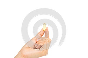 Woman`s hand holding Fish oil capsules with omega 3 and vitamin D healthy diet concept