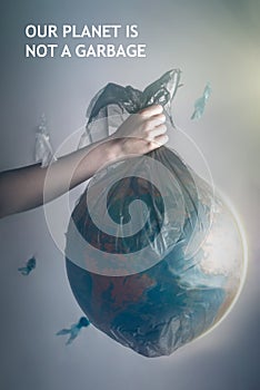 A woman`s hand holding a garbage bag with a globe of planet Earth.The inscription OUR PLANET IS NOT A GARBAGE.