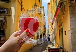 Woman s hand with a glass of raspberry Lambic ale at a restaurant in Nice France photo