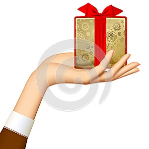 Woman`s hand holding gold gift box with red ribbon isolated on w